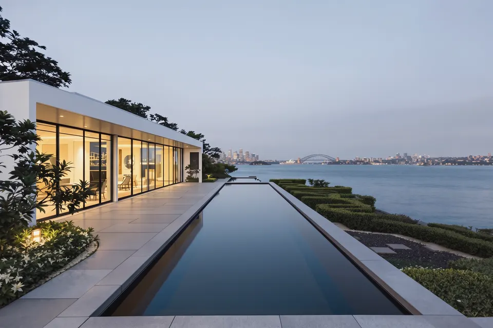 Harbourfront residence in Point Piper with a pool terrace looking across to the Harbour Bridge and Opera House at dusk